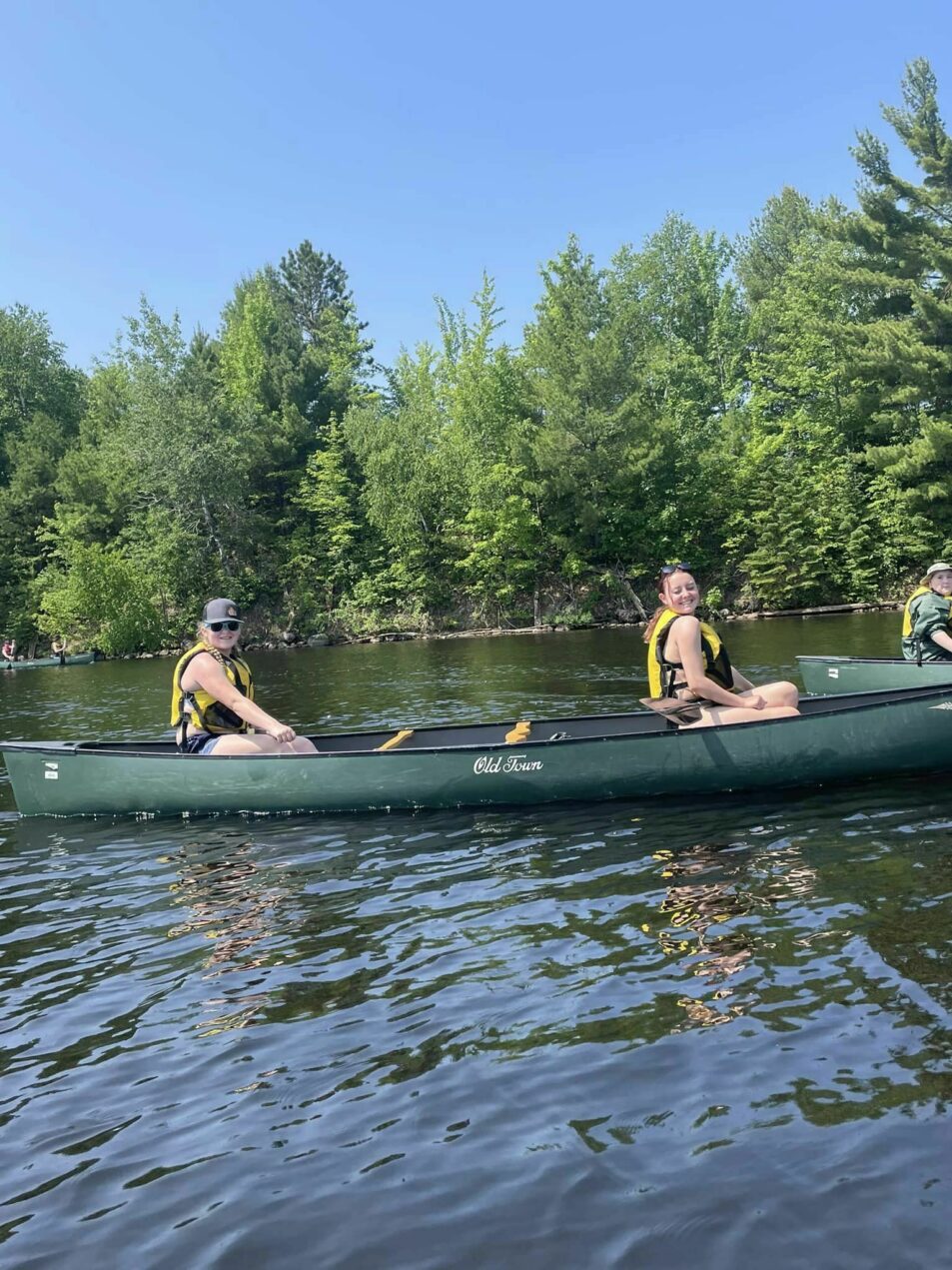 campers smile in canoe