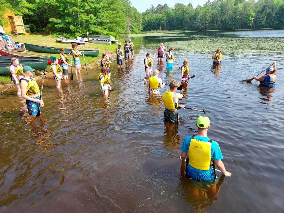 Campers stand in shallow water