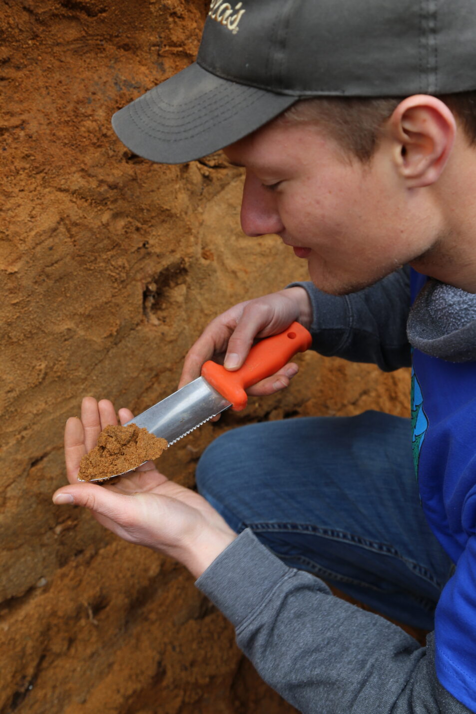 boy examines soil sample